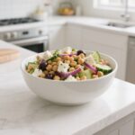 Final chickpea salad recipe served in a white bowl on kitchen counter