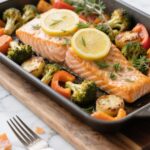 Lemon herb salmon with roasted vegetables in a baking dish