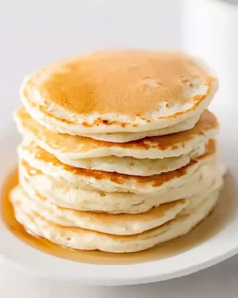 Beautiful reindeer pancakes decorated with chocolate chip eyes, pretzel antlers, and berry noses on a festive holiday breakfast table